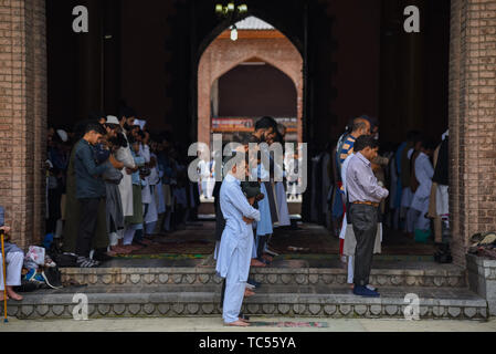 Musulmani del Kashmir adoratori offrendo Eid-ul-Fitr preghiera alla madrassa Jamia Masjid in Srinagar. Eid-ul-Fitr festival segna la fine del Santo mese di digiuno del Ramadan. Foto Stock