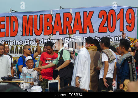 Con i leader musulmani e gli anziani, congratularmi con ogni altro durante l'Eid-ul-fitr festival a Manila. Eid-ul-Fitr è una festa che segna la fine del Ramadan, mese-lungo periodo di digiuno dall alba al tramonto per cercare il perdono dei peccati, aumentare il controllo di sé e di esercizio della carità. Questa celebrazione è la festa della rottura del digiuno. Foto Stock