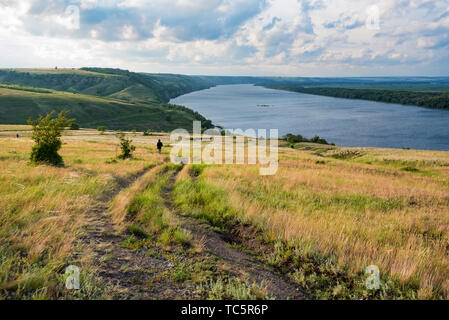 Vista incredibile di escursionisti a piedi nella steppa estiva con il lago bellissimo paesaggio Foto Stock