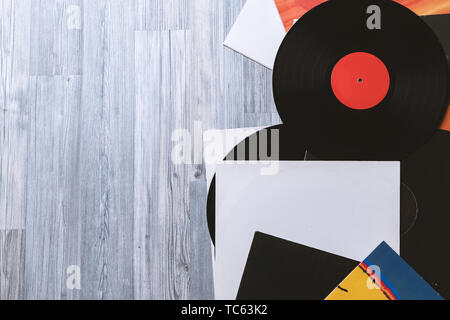 Nero vinile e copertine album sullo sfondo della loro grigio di tavole di legno.in stile vintage con copia spazio. Foto Stock