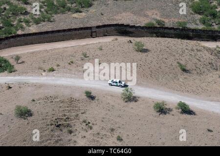 Un U.S. Pattuglia di Confine veicolo pattuglie di souther il bordo lungo un tratto a distanza di Sonora Messico come visto da un U.S. Dogane e Pattuglia di Confine UH-60 Blackhawk elicottero 29 Maggio 2019 oltre Sasabe, Arizona. Foto Stock