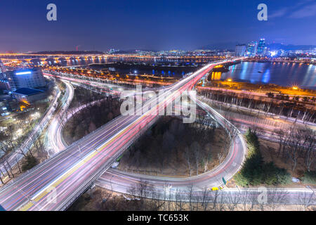 Korea Travel, auto passando in intersezione, Fiume Han e ponte di notte nel centro cittadino di Seoul, Corea del Sud. Foto Stock
