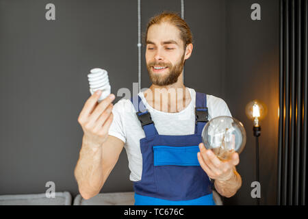 Tuttofare scegliendo tra risparmio energetico e lampadine tradizionali a casa Foto Stock