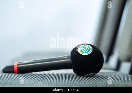 04 giugno 2019, France (Francia), Bruz: un microfono con il logo DFB giace su una sedia nel corso di una conferenza stampa del tedesco della Nazionale femminile football team prima del 2019 FIFA World Cup in Francia. Foto: Sebastian Gollnow/dpa Foto Stock