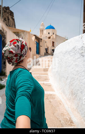 Coppia giovane in viaggio. Donna che mantiene la mano di uomo e apre la strada a nuovi luoghi e belle destinazioni, Shot nell isola greca di Santorini Foto Stock