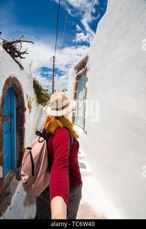 Coppia giovane in viaggio. Donna che mantiene la mano di uomo e apre la strada a nuovi luoghi e belle destinazioni, Shot nell isola greca di Santorini Foto Stock