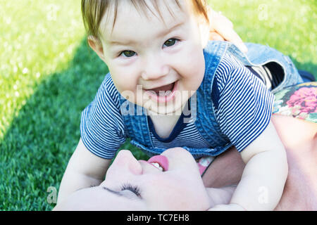 Mamma e Bambino sono sdraiati sull'erba verde Foto Stock