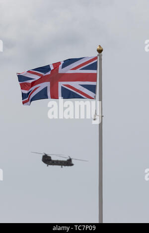 Un elicottero Chinook battenti dietro un'unione jack flag su un pennone Foto Stock
