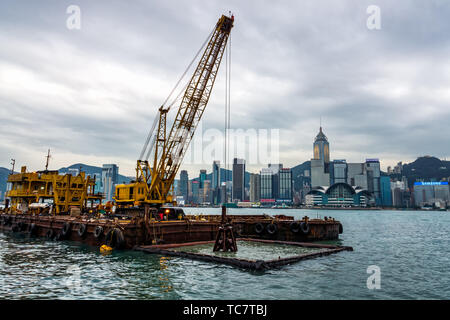 Hong Kong, Cina, marzo 2013 il dragaggio nel porto di Hong Kong, pulire il letto di acqua mediante la movimentazione di fango, erbacce e rifiuti con un dragare Foto Stock