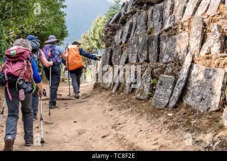 Phakding, Nepal - Ottobre 25, 2018: turisti trekking, Thado Koshi Gaon, buddista mani da parete a metà del percorso per Phakding sul Campo Base Everest Trek Foto Stock