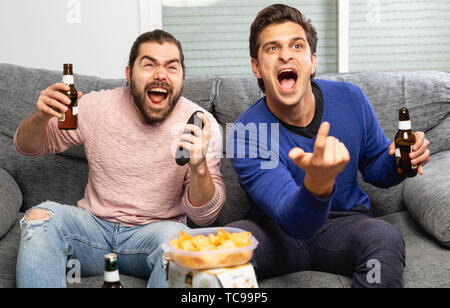 Gli uomini bere birra e guardare la partita in tv Foto Stock