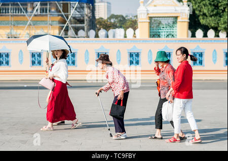 Una vecchia signora cambogiana fa il suo modo attraverso la strada di fronte al Grand Palace, Phnom Penh Cambogia del Sud Est Asiatico. Foto Stock