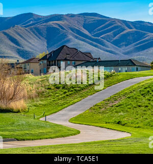 Telaio strada quadrato su una collina con un luminoso verde erbe e belle case a distanza Foto Stock