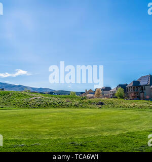 Telaio quadrato case residenziali su un terreno con vivido verde erbe visto in una giornata di sole Foto Stock