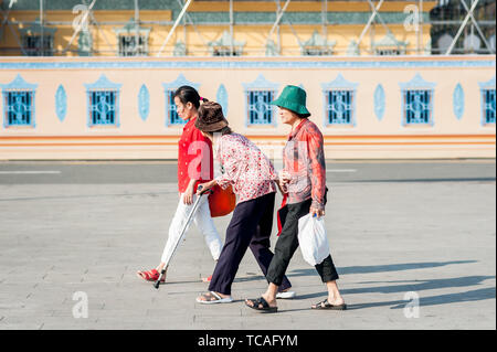 Una vecchia signora cambogiana fa il suo modo attraverso la strada di fronte al Grand Palace, Phnom Penh Cambogia del Sud Est Asiatico. Foto Stock