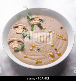 Minestra di crema con i funghi, i funghi e le patate in una ciotola bianco Foto Stock