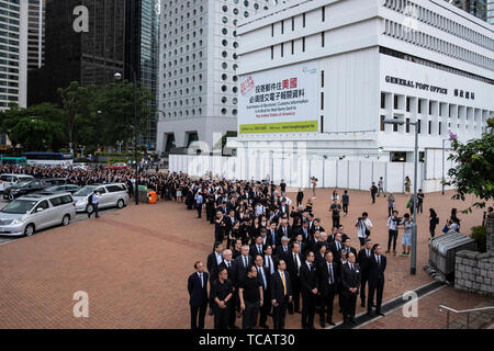 Centinaia di avvocati e professionisti legali abito nero di prendere parte durante la marcia silenziosa contro la legge in materia di estradizione da parte della Corte di appello al governo centrale complesso in Hong Kong. I critici la paura di qualsiasi accordo di estradizione potrebbe lasciare entrambe le figure aziendali e i dissidenti in Hong Kong vulnerabile alla Cina di tribunali politicizzato, fatalmente minando un business hub che ha prosperato spento la sua reputazione per un trasparente e un sistema giudiziario indipendente. Foto Stock