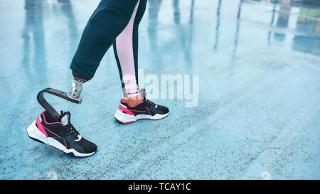 Wake up e allenamento. Immagine ritagliata di atleti disabili donna con gamba protesico in piedi sul Stadium. Sport concept. Sportivo disabili Foto Stock