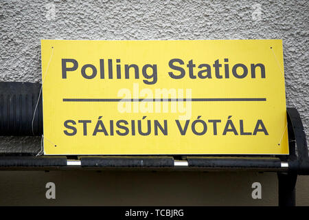 Bilingue inglese irlandese stazione di polling firmare al di fuori di una scuola irlandese durante il tempo di elezioni Foto Stock