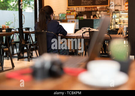 Giovane donna studenti che lavorano con il computer portatile in cafe. Foto Stock