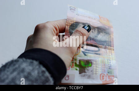 Bank of Scotland £10 nota, un tenner, di banconote della sterlina, maggio 2019, UK.Donna holding 10 libbre carta banca scozzese nota su backg isolato Foto Stock