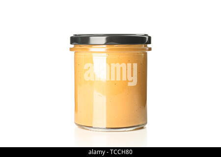 Crema di burro di arachidi in un barattolo di vetro isolato su sfondo bianco. Un prodotto tradizionale della cucina americana Foto Stock