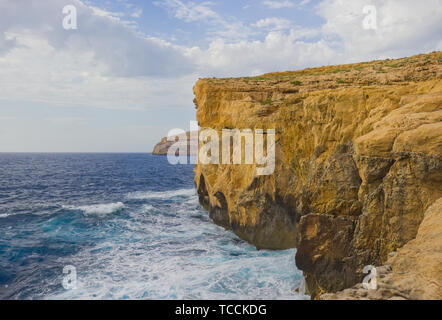 Scogliere dove Azure Window crollato illuminato dalla luce del tramonto sulla costa dell'isola di Gozo, Malta. Foto Stock