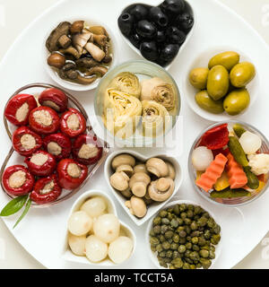 Italiano sottaceti tradizionali su una piastra. tonno peperoni ripieni, Carciofini in olio, olive, funghi, capperi. copia di spazio. Foto Stock