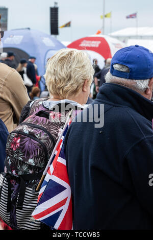 Una donna ad un evento esterno con un union jack flag bloccato nel suo zaino Foto Stock