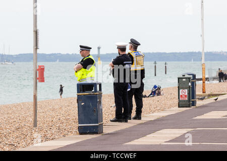 Tre inglesi ufficiali della polizia di pattuglia al mare Foto Stock