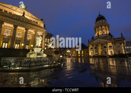 Illuminato il monumento a Schiller, la Konzerthaus di Berlino e Französischer Dom (cattedrale francese) presso la piazza Gendarmenmarkt a Berlino, Germania, al tramonto. Foto Stock