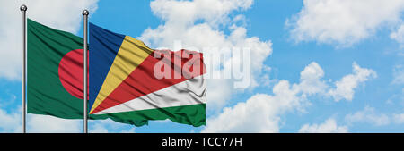 Bangladesh e Seychelles bandiera sventolare nel vento contro bianco torbido cielo blu insieme. Concetto di Diplomazia e relazioni internazionali. Foto Stock