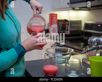 Donna versando pompelmo margarita in bicchieri di vino per party drink Foto Stock