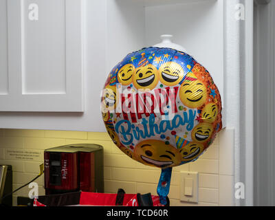 Buon compleanno palloncino con facce sorriso flottante in una casa pronta per party Foto Stock