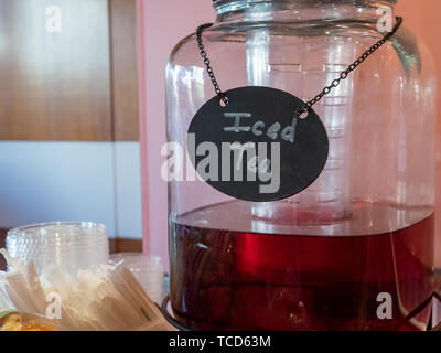 Ice Tea etichetta in gesso in glass pitcher erogatore accanto al servizio di utensili Foto Stock
