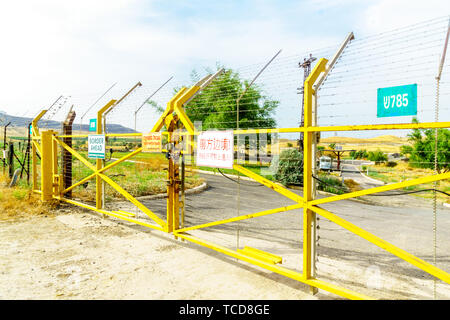 Gesher, Israele - 04 Giugno 2019: la valle del Giordano e il cancello di confine con cartelli di avvertimento, vicino al confine tra Israele e la Giordania, nella vecchia Gesher Foto Stock