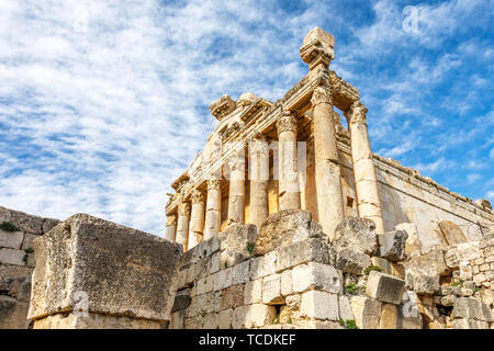 Colonne di antico tempio romano di Bacco con rovine circostanti e cielo blu in background, Beqaa Valley, Baalbeck, Libano Foto Stock