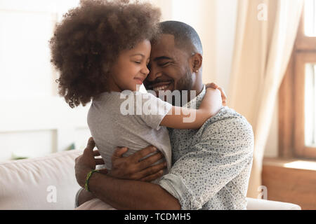 Felice padre africano holding abbracciando grazioso fanciullo figlia Foto Stock