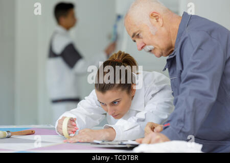 Pittore femmina utilizzando del nastro adesivo Foto Stock