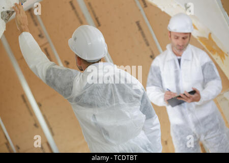 Lavoratori intonacatura di una parete utilizzando cazzuola Foto Stock