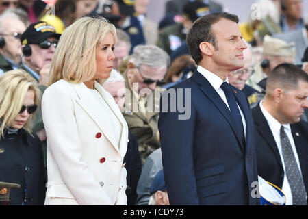Il Presidente francese Emmanuel Macron e sua moglie, First Lady Brigitte Macron, stand insieme durante il settantacinquesimo D-Giorno Anniversario cerimonia in Normandia Cimitero e memoriale americano di Colleville-sur-Mer, Francia, giugno 6, 2019. Più di 1.300 U.S. I membri del servizio, collabora con 950 truppe provenienti da tutta Europa e Canada, sono confluite nel nordovest della Francia per commemorare il settantacinquesimo anniversario della Operazione Overlord, la seconda guerra mondiale invasione alleata della Normandia, comunemente noto come D-Day. Foto Stock