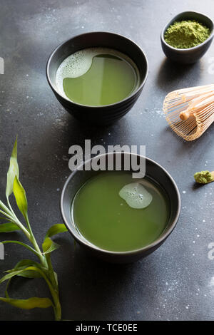 Due organico Verde matcha tè nella ciotola sulla tavola nera. Close up. Spazio per il testo. Foto Stock