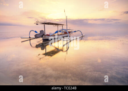 Jukung tradizionale barca ancorata sulla spiaggia Sanur, Bali, Indonesia Foto Stock