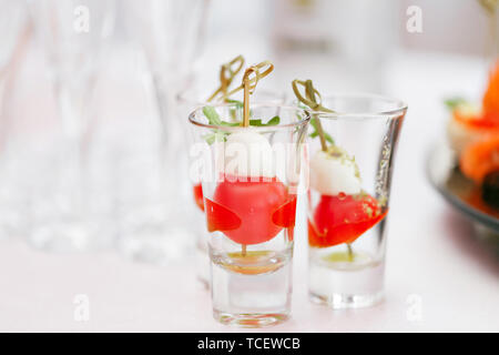 Antipasto Caprese. Pomodori ciliegia,mozzarella e basilico su spiedini. . Pesto. Buffet della cena di gala. Assortimento di stuzzichini. Servizio banchetti. Foto Stock