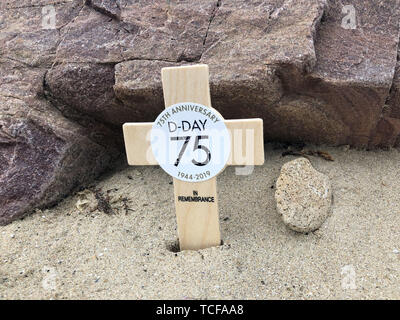 Una croce è prevista sulla spiaggia d'oro in Arromanches-les-Bains, Francia, dove i veterani sbarcati 75 anni fa, per ricordare i loro compagni caduti. Foto Stock