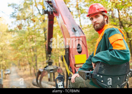 Forest agricoltore di gruista su lo spedizioniere durante la registrazione nel raccolto di legno Foto Stock