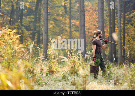 Giovane ranger o lavoratore della foresta è piantare alberi per la sostenibilità e la conservazione Foto Stock