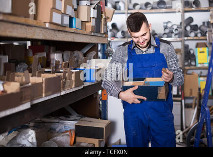 Lavoratore europeo controllo piccoli dettagli per ingegneria sanitaria in officina Foto Stock