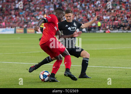 Toronto, Canada. Il 7 giugno, 2019. Richie Laryea (L) di Toronto FC con vies Kelyn Rowe di Sporting Kansas City durante il 2019 Major League Soccer (MLS) corrispondono con Sporting Kansas City presso BMO Field a Toronto in Canada Giugno 7, 2019. La partita si è conclusa con un pareggio per 2-2. Credito: Zou Zheng/Xinhua/Alamy Live News Foto Stock