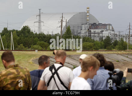 Kiev, Ucraina. Il 7 giugno, 2019. I visitatori guardano sul nuovo confinamento sicuro oltre il quarto blocco della centrale nucleare di Cernobyl di Chernobyl, in Ucraina, il 7 giugno 2019. Il successo di un'U.S. Del HBO miniserie televisiva "Chernobyl' ha rinnovato interesse in tutto il mondo su dell'Ucraina 1986 catastrofe nucleare. Turismo a Cernobyl ha spiked 40% dopo il debutto della serie HBO in maggio, agenzie di giro segnalati. Credito: ZUMA Press, Inc./Alamy Live News Foto Stock